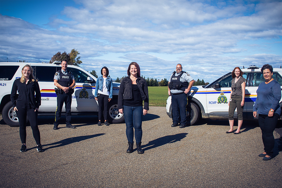 On the photo, we can see the social workers and clinical leaders from the mobile crisis team; from left to right: Joanie Sivret, Caroline Bulger, Janie Gosselin, Marie-Hélène Robichaud and Manon Robichaud. The two members of the RCMP in the back are Sergeant Jonathan Simard on the left and Sergeant Jocelyn LeBouthillier on the right. 